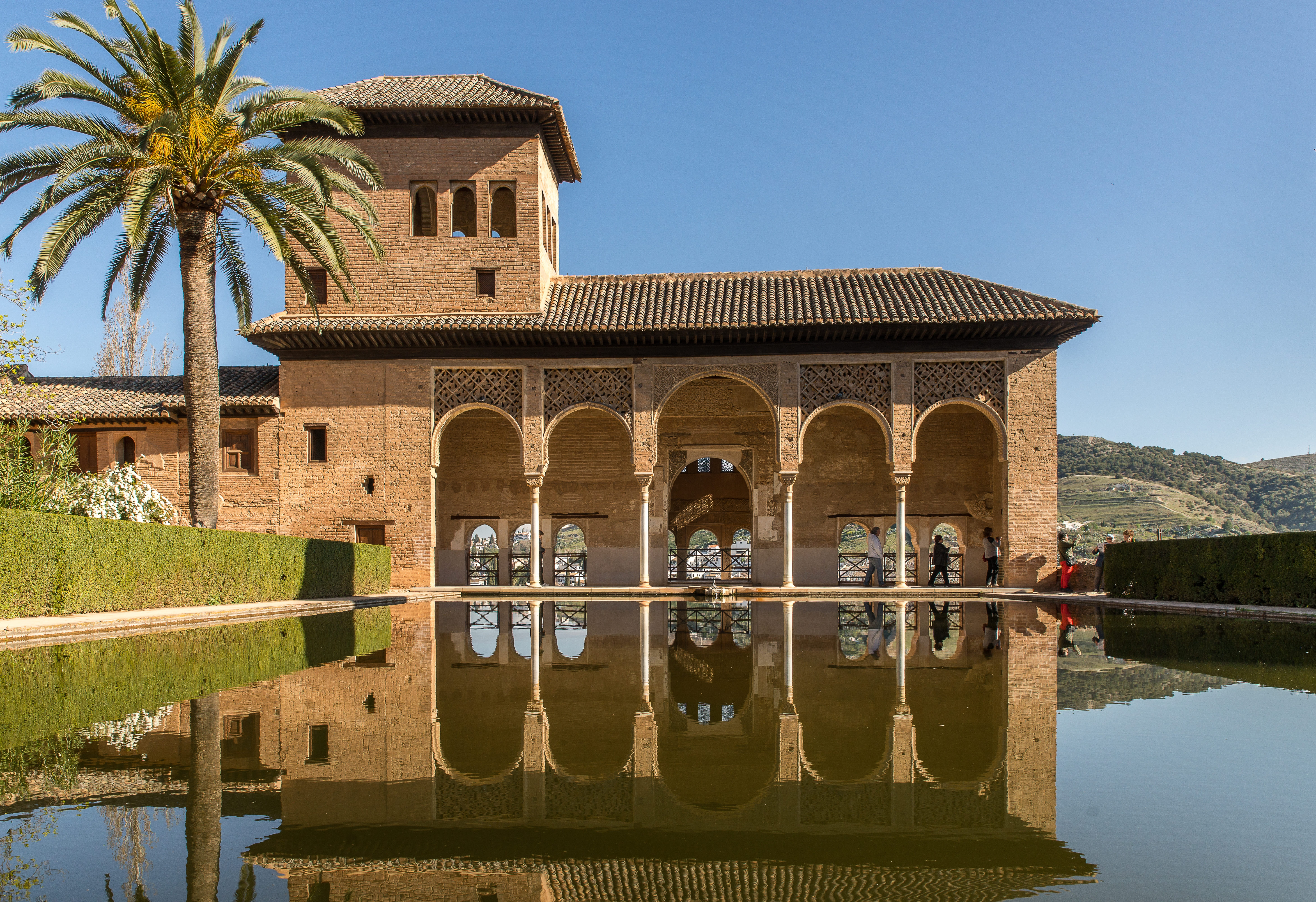 Moorish palace with reflecting pond and palm tree — architectural heritage that defines Marrakech Medina real estate